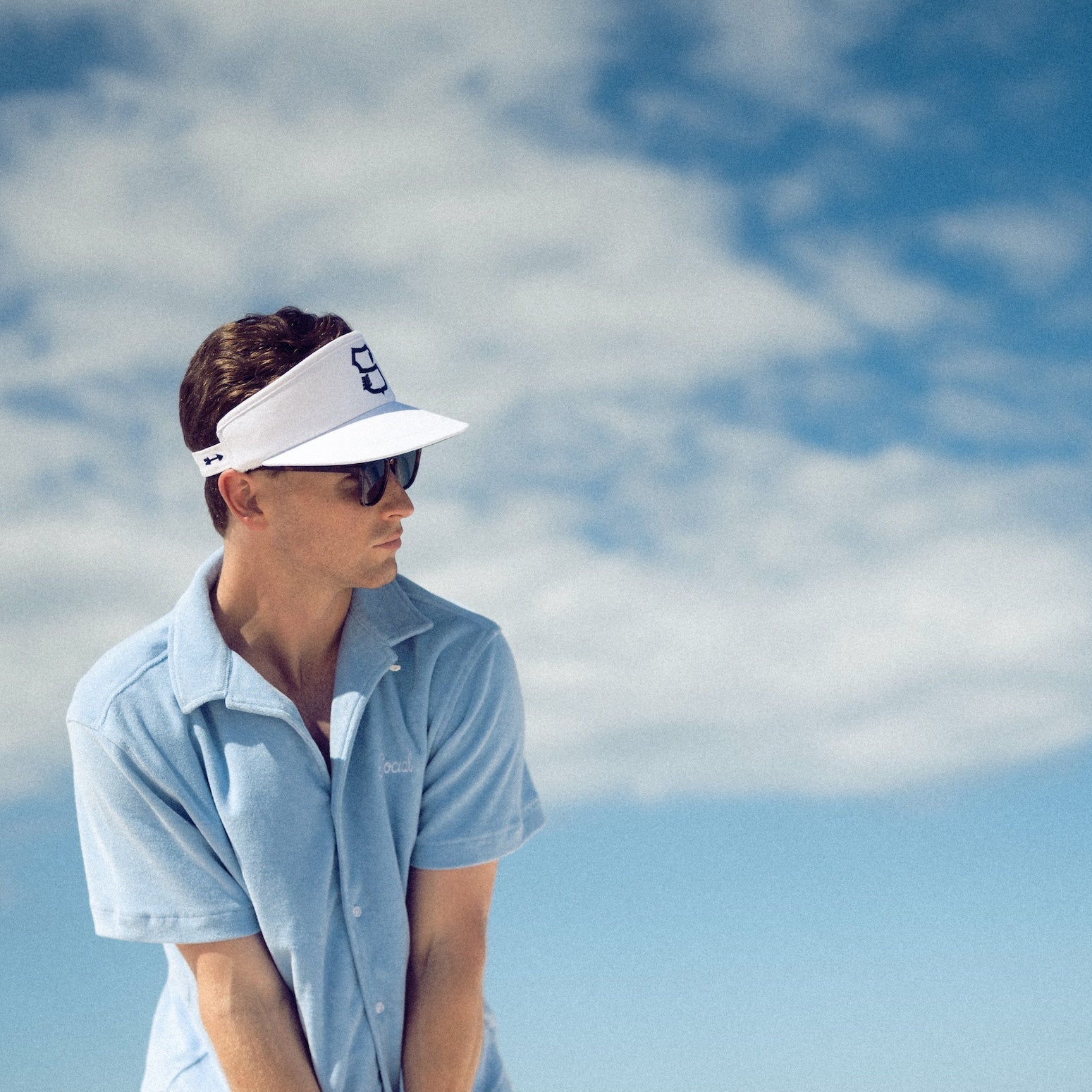 Man playing golf on a beach with a clear blue sky