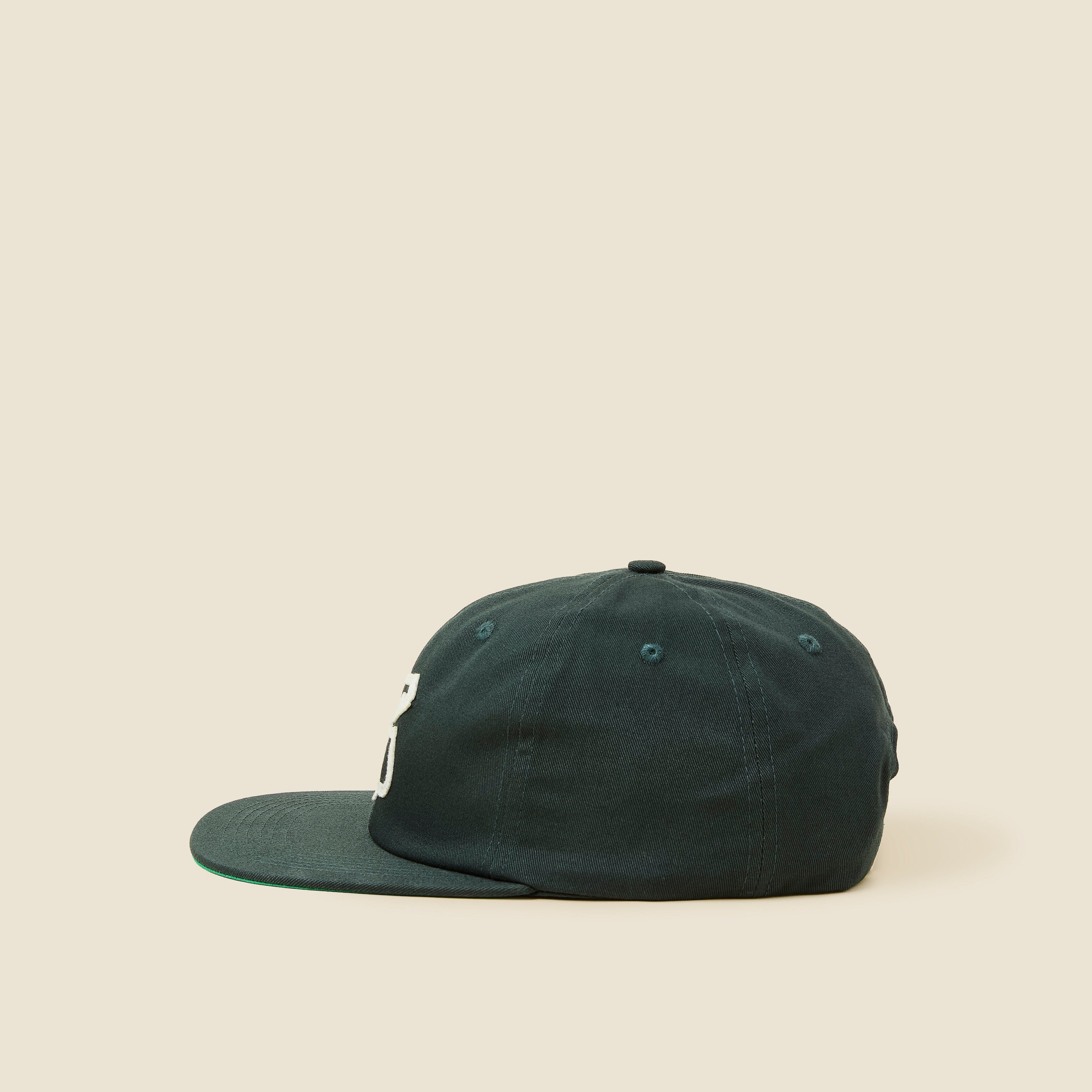 Dark green cap on a beige background
