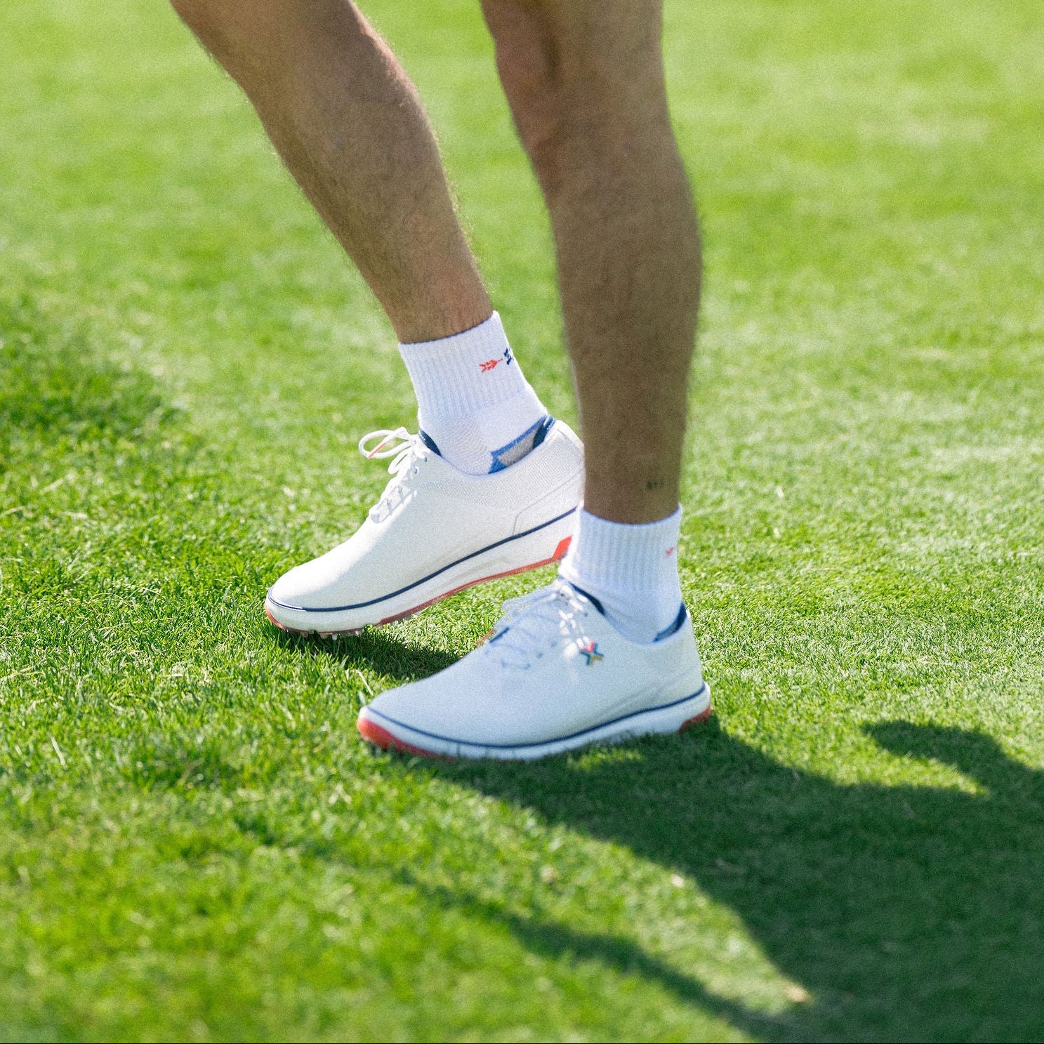 white golf shoes and socks on a green golf course